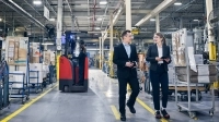 Une conseillère et un PDG sur le plancher d'une usine