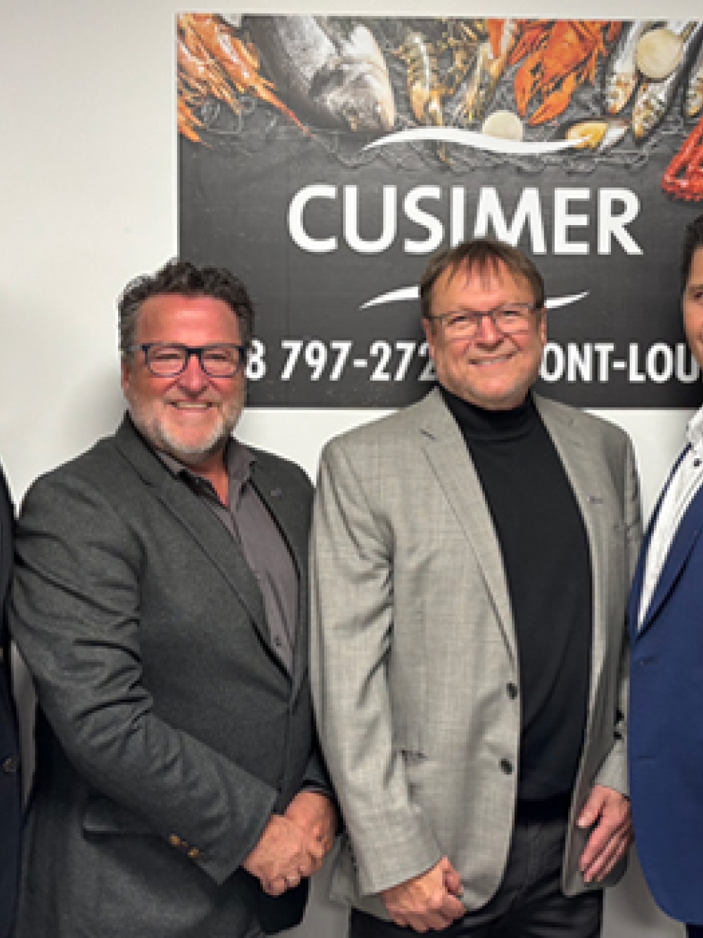 Groupe de six personnes debout dans un local, posant devant une affiche de l’entreprise Cusimer.