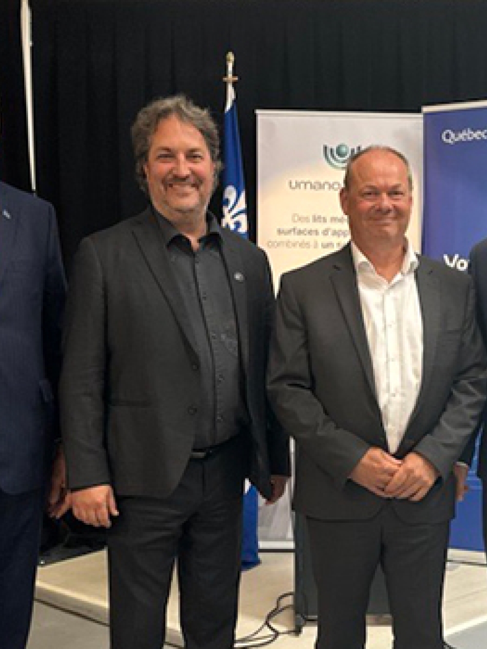 Groupe de personnes debout devant des bannières portant les logos d’Umano Médical et du gouvernement du Québec lors d’une annonce officielle.