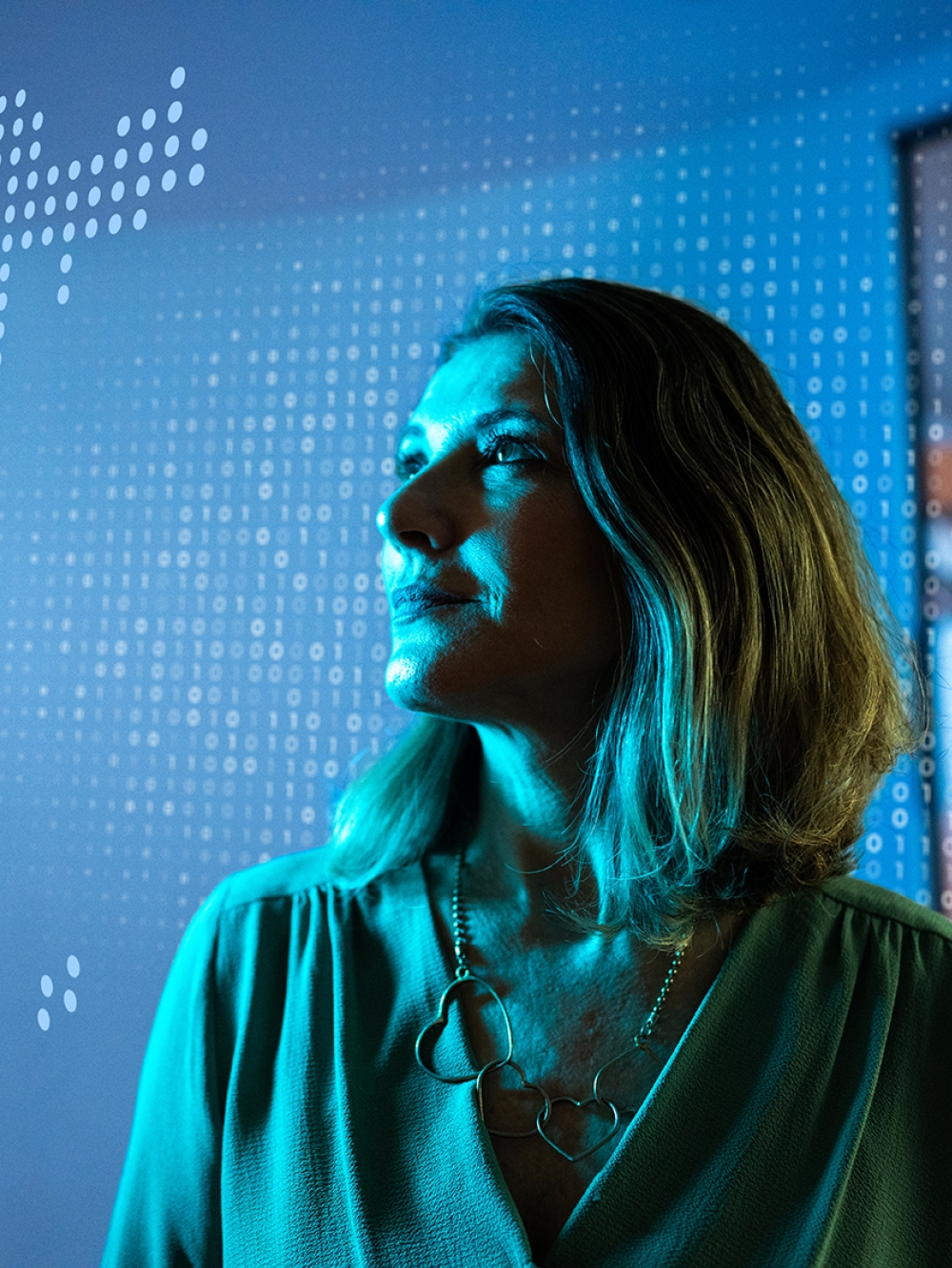 Une femme devant une carte du monde regarde au loin