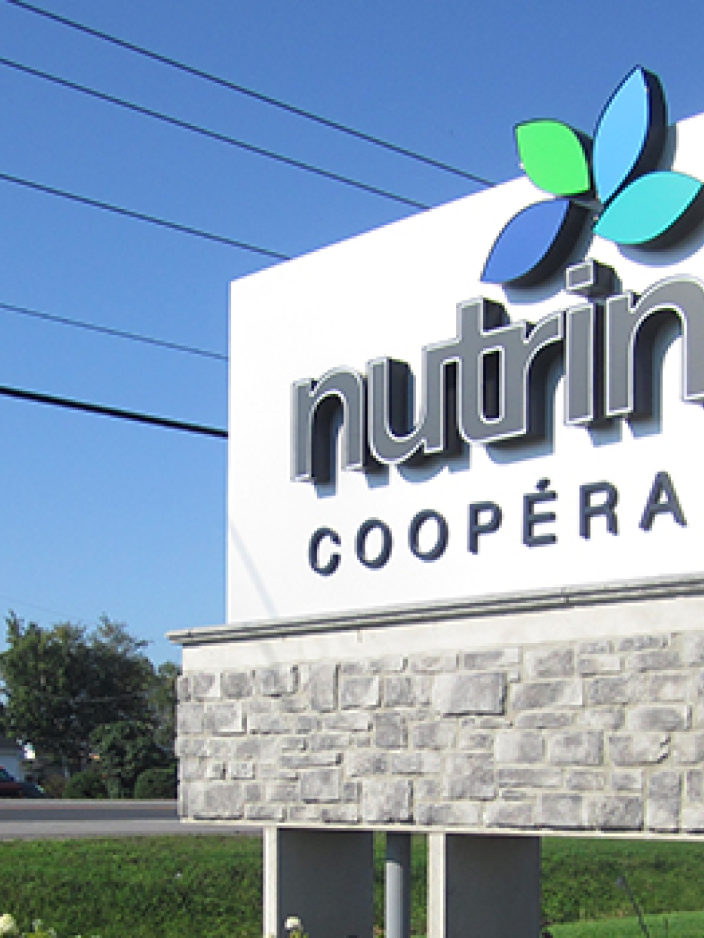Enseigne extérieure de la coopérative Nutrinor affichée sur une structure de pierre.