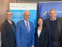roupe de six personnes posant à l’intérieur devant des bannières gouvernementales, dont celles de Développement économique Canada et d’Investissement Québec.