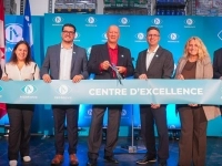 Groupe de personnes lors d’une cérémonie d’inauguration, tenant un large ruban turquoise portant l’inscription « Centre d’excellence », devant un fond aux couleurs de NuMove.