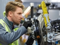 Un homme travaillant sur une pièce de véhicule
